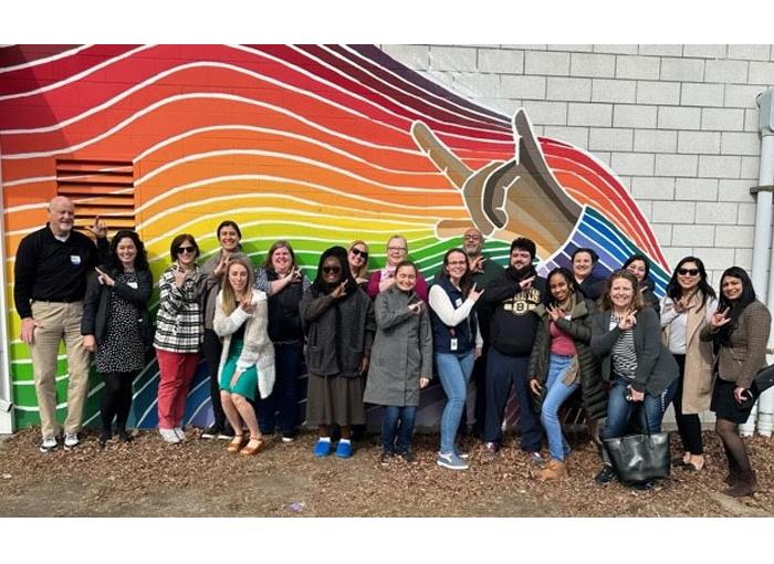 MetroWest Leadership Academy stands in front of the TLC Rainbow Mural