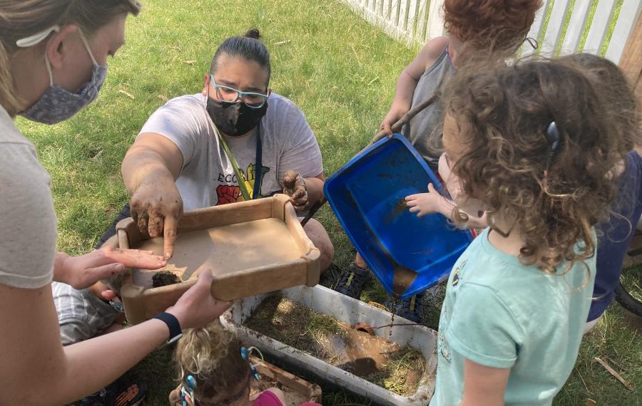 A teacher and students are participating in activities outside.