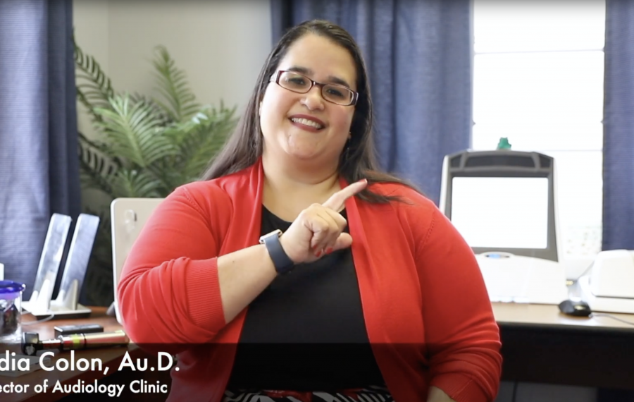 Female sitting in office signing in ASL.