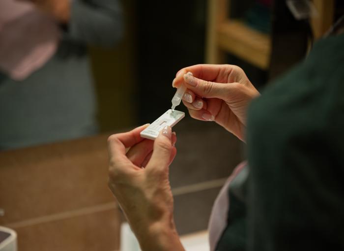 Two hands holding an at-home covid test
