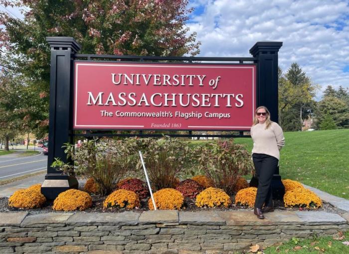 Megan Vargo stands next to the University of Massachusetts sign