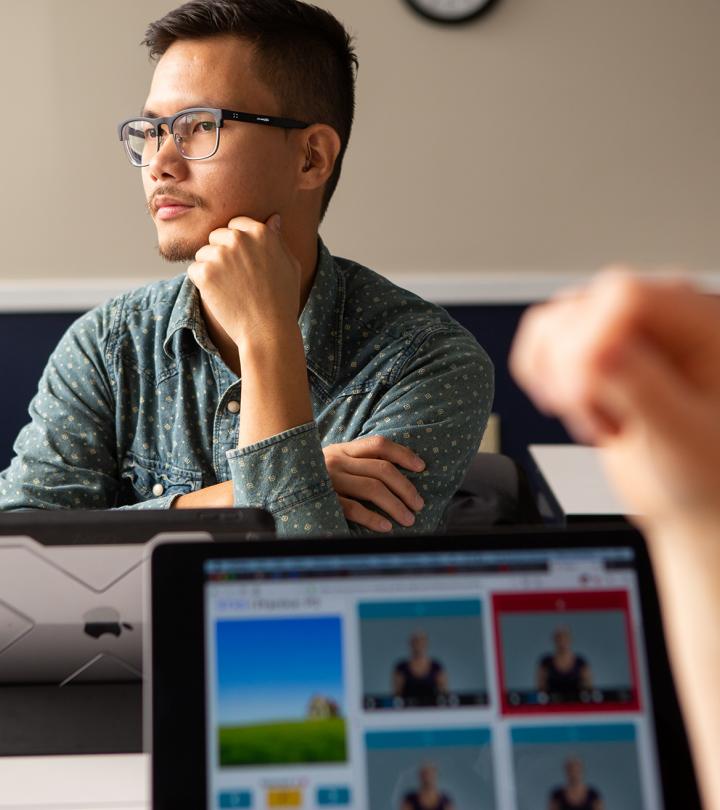 A white male with glasses sitting at a conference table.
