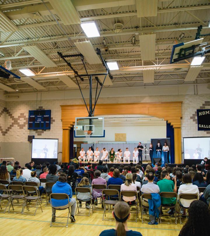 Students watching a play at school gym