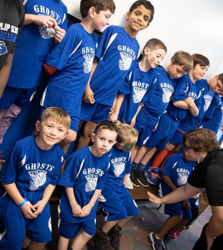 A group of elementary students posing in their basketball uniforms.