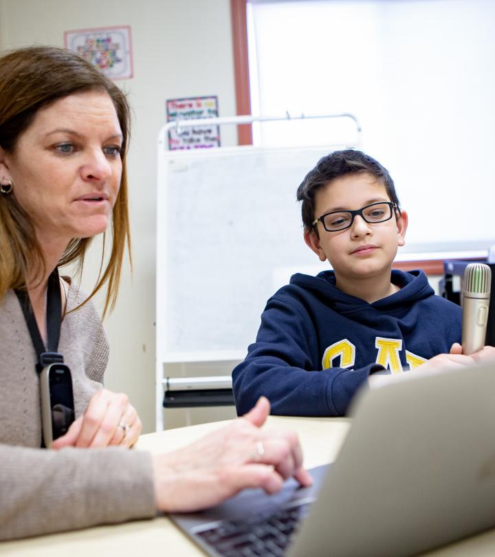 Student and teacher looking at laptop.