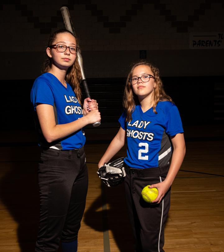 Two MPS softball players posing with baseball bat and softball ball. 