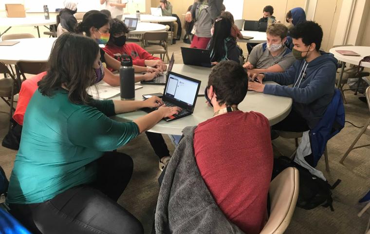 A group of students sit around a table.