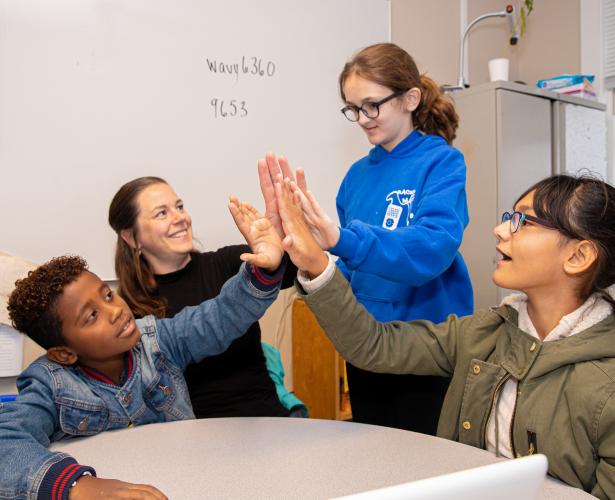 A group of students high-five each other.