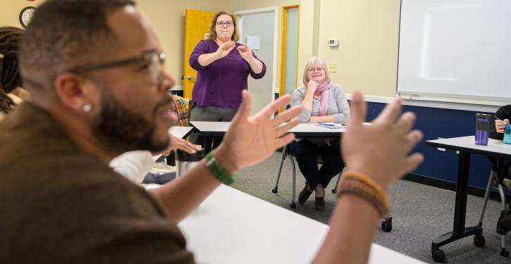 an interpreter interpreting staff talking in meeting.