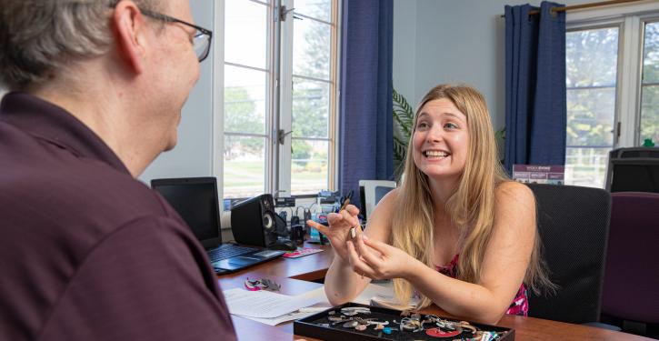 audiologist helping client with hearing aid
