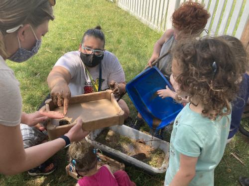 A teacher and students are participating in activities outside.