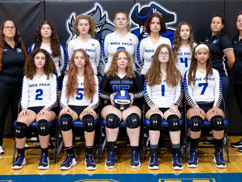 MPS Girls Volleyball Team photo. Two rows of athletes. Front row is sitting, back row is standing.