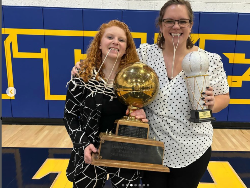 Amanda Geffen and Emily Larose grinning with their 1st Place Trophy, the Traveling Trophy and a piece of the championship net.